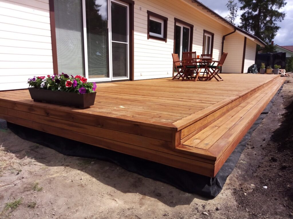 Valmis puitterrass elamu kõrval – tõstetud konstruktsioon, puidust laudis.